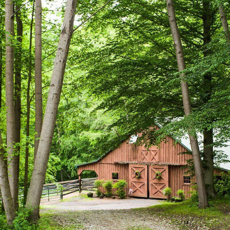 The barn at Solitude Stables tucked among tall green trees in Anne Arundel County, Maryland