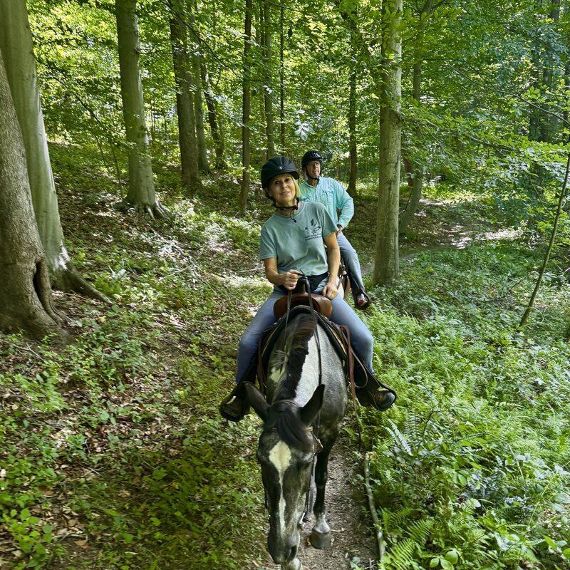 An instructor leads two riders along a wooded trail at Solitude Stables in Anne Arundel County, MD